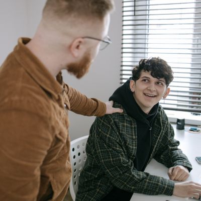Adolescente conversando con un adulto en un ambiente de confianza, representando acompañamiento emocional y apoyo para adolescentes