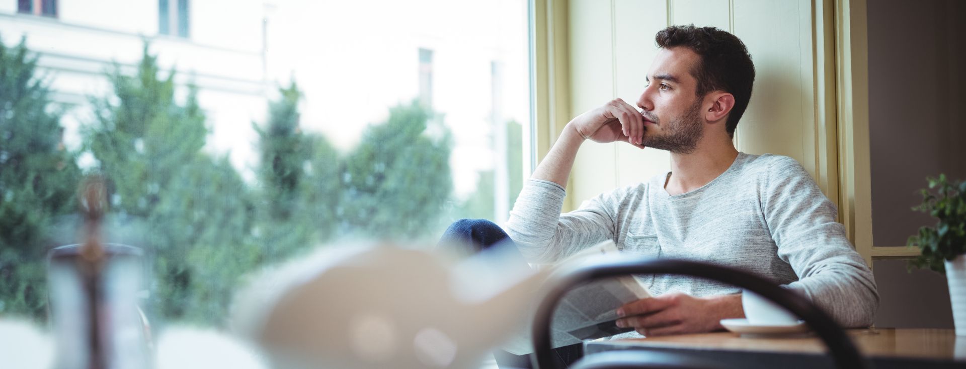 hombre en pausa mirando por la ventana en proceso de acompañamiento emocional en Neuronas Magicas